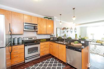 A kitchen with wooden cabinets and a black and white checkered floor